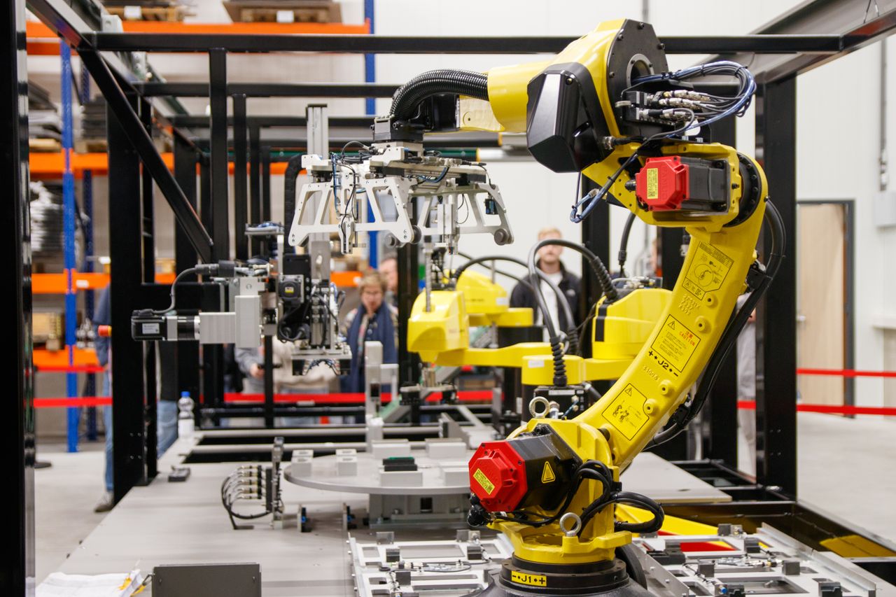 Services Close-up of a yellow industrial robotic arm in action at a modern manufacturing facility.